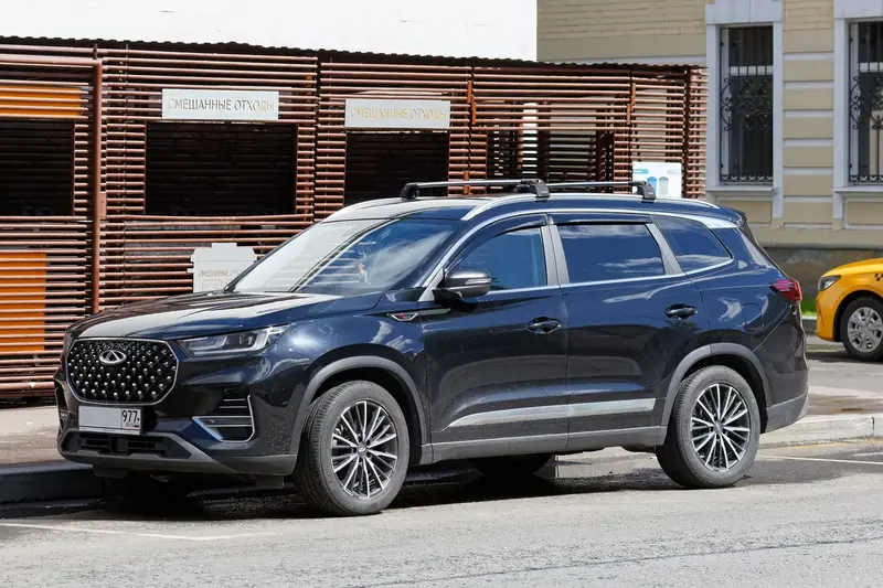 Chery Tiggo 8 Pro שחור עם מוטות גג, מבט מהצד ומלפנים, חונה ברחוב
